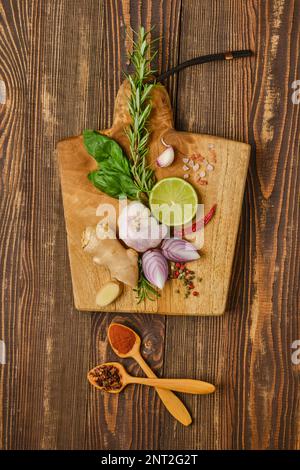 Composition with different spice and seasonings for cooking on wooden cutting board Stock Photo