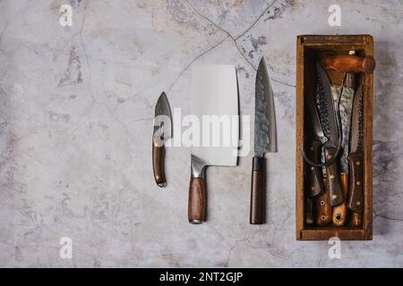 Used forged tools of butcher on stone background Stock Photo