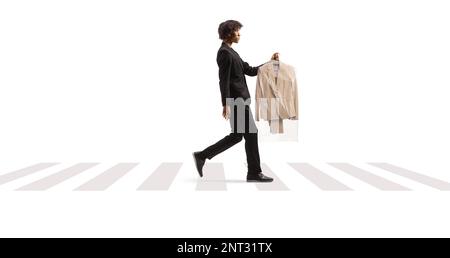 Full length profile shot of an african american man collecting suit from dry cleaners and crossing street isolated on a white background Stock Photo