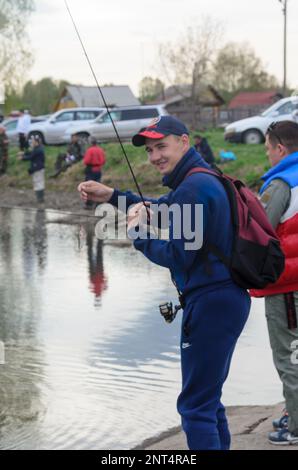 Russian modern male fisherman fishes on an ultralight spinning rod