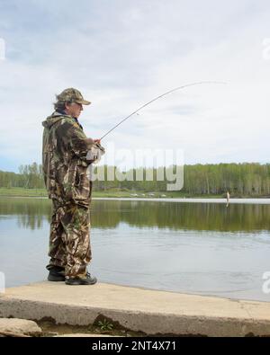 Russian modern male fisherman fishes on an ultralight spinning rod