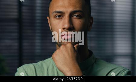 Portrait serious pensive thoughtful african american man businessman entrepreneur leader standing indoors looking camera thinking pondering about Stock Photo
