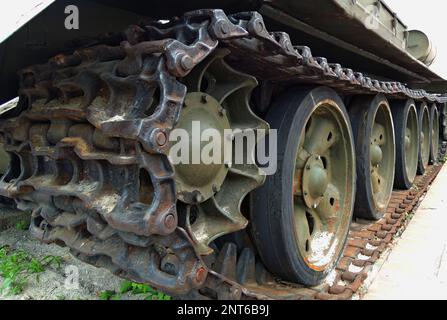 Rusty tracks of a crawler military armored carrier vehicle closeup photo for a vertical story Stock Photo