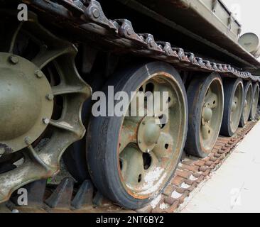 Tracks and rollers of a tracked tank packed with sand with traces of rust Stock Photo