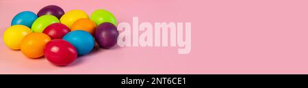 Wide Easter banner empty. Multi-colored eggs on a pink background. Stock Photo