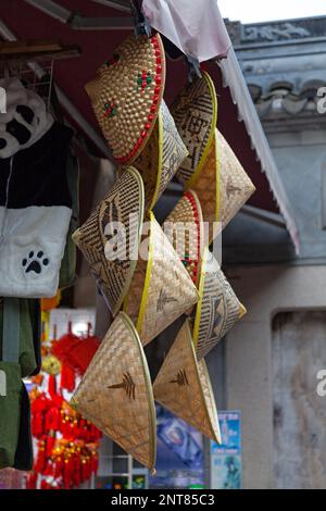 Straw conical hats for sale at a shophouse in YuYuan Market in Shanghai, China. Stock Photo