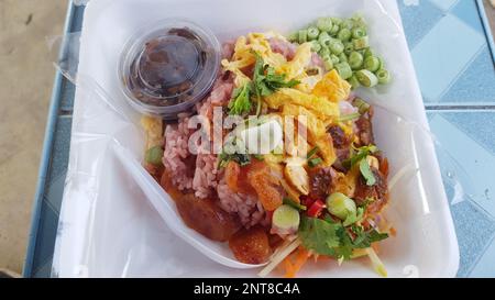 Shrimp paste fried rice with omelette, vegetables and meat in a styrofoam box. Stock Photo