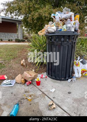 Unadilla, GA / USA - November 20, 2022:  A trash can overflows with garbage at a South Georgia rest stop during the Thanksgiving holidays. Stock Photo