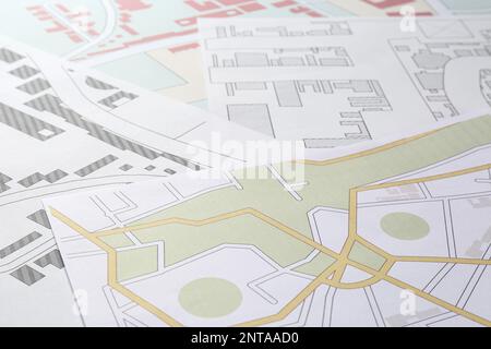 Many different cadastral maps of territory with buildings as background, closeup Stock Photo