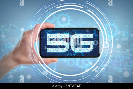 Woman using smartphone with 5G network system against light blue background, closeup Stock Photo