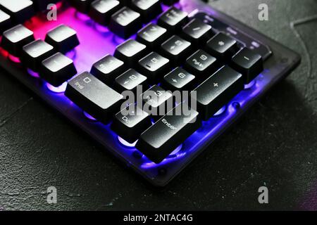 Modern keyboard with RGB lighting on grey table, closeup Stock Photo
