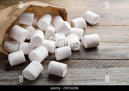 Delicious puffy marshmallows on wooden table, closeup Stock Photo