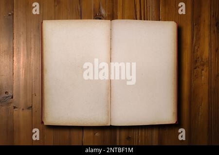 Close-up on a red book opened with copy space on a brown woodboard. Stock Photo