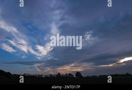 Wind turbines against a cloudy sky Stock Photo