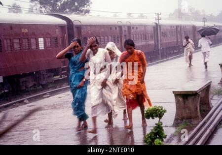 Women walking in the rain at kollam railway station, Kerala, South India, India, Asia Stock Photo