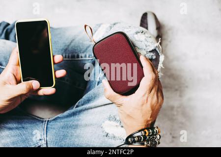 relaxing concept, the man using wireless portable speaker for music listening. Stock Photo