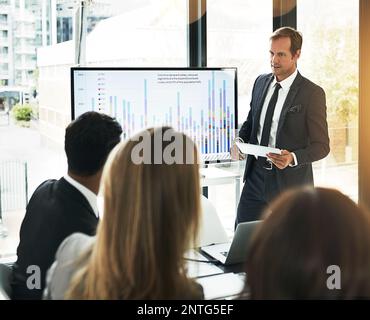 Using his tablet for notes on his presentation. a businessman using a digital tablet while doing a presentation. Stock Photo