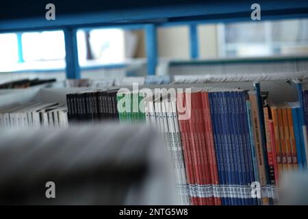 Books Are Tightly Arranged On Blue Iron Shelves In The School Library Stock Photo