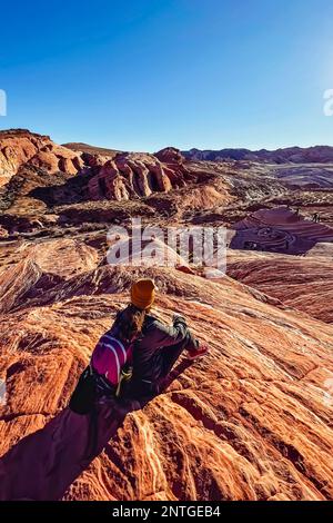 Woman sitting on a rock with a view of Valley of Fire, Nevada Stock Photo