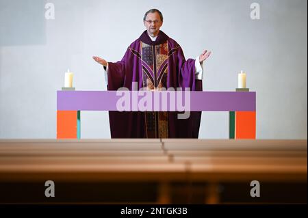 PRODUCTION - 24 February 2023, Saxony-Anhalt, Halle (Saale): Catholic priest Magnus Koschig stands at the altar table of Halle's Church of the Holy Cross in a purple priest's robe. The 62-year-old assumes that in just ten years there will be only 20 priests in the Magdburg diocese instead of the current 55 due to aging. (to dpa 'Fewer priests, more laity: Catholic diocese in transition') Photo: Heiko Rebsch/dpa Stock Photo