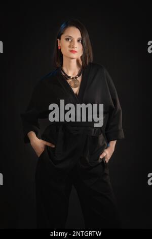 Mixed race brunette woman in black silk pajamas Stock Photo