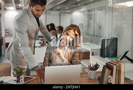 Hes always willing to help. a young businessman helping an older female colleague in the office. Stock Photo