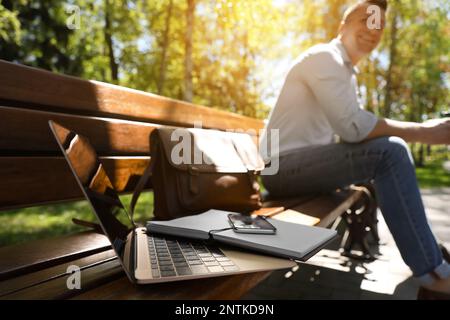 Man taking break during work in park, focus on laptop Stock Photo