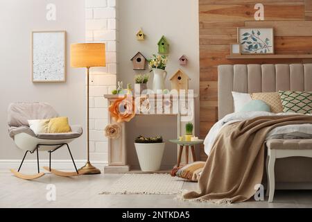 Decorative fireplace with modern furniture in bedroom. Interior design Stock Photo