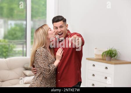 Happy couple with key from their new house indoors Stock Photo