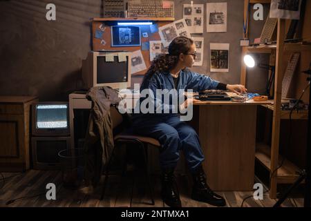 Beautiful engineer repairing laptop computer. Young women repairing motherboard in computer retro repair shop. Worker with tools. Computer Hardware. D Stock Photo