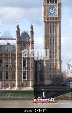 London, UK. 27 February, 2023. Extinction Rebellion activists sail a Viking long boat past the Houses of Parliament, in a protest against allowing unt Stock Photo