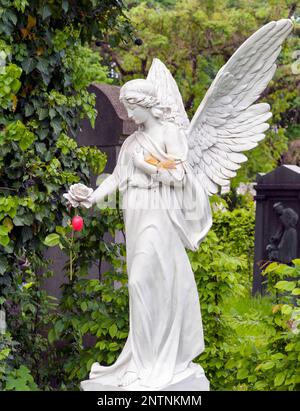 Big angel made of marble with red Easter egg Stock Photo