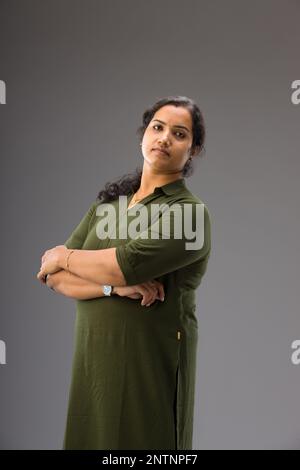 Portrait of an Indian woman,Standing pose showing different gesters, with grey background ,isolated. Stock Photo