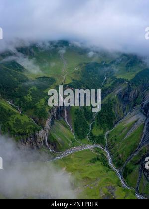 Aerial shot of several large waterfalls cascading down a steep cliff ...