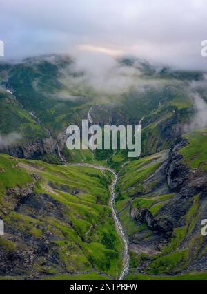 Aerial shot of several large waterfalls cascading down a steep cliff ...