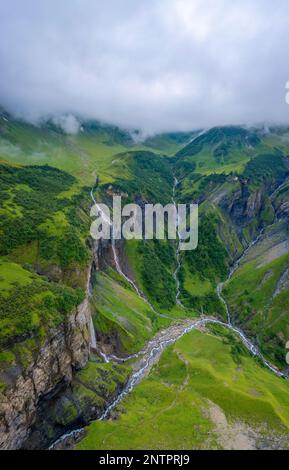 Aerial shot of several large waterfalls cascading down a steep cliff ...