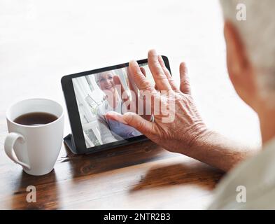 With new technology, were never far apart.... A senior woman having a video chat with her husband on a digital tablet. Stock Photo