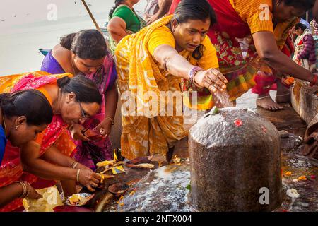 Pilgrims making a ritual offering, and praying, ghats in Ganges river, Varanasi, Uttar Pradesh, India. Stock Photo