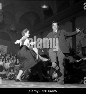 Dancing in the 1950s. A young couple is pictured on the dance floor at Nalen Stockholm, dancing the Sluefoot. Dancing the Sluefootcan be done to most any jazz beat, som of the steps in this dance are referred to as Slueing. The dance features considerable leg jolting, arm jabbing and shuffling.  A dance that was made somewhat popular by american dancers Leslie Caron and Fred Astaire in the 1955 film Daddy long legs. Sweden 1957 Conard ref 3122 Stock Photo