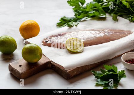 cooking of the sole flatfish meuniere style, raw fish and other ingredients on the table Stock Photo