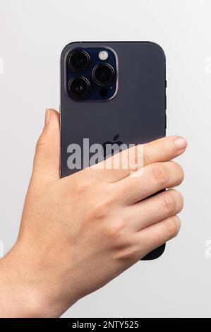 New york, USA - February 24, 2023: Iphone pro in woman hand  isolated on white studio background Stock Photo