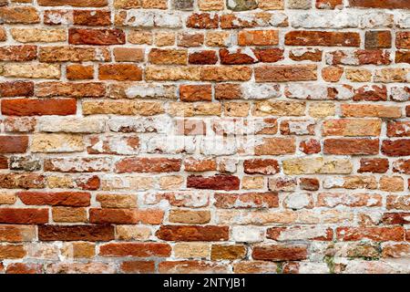 Full frame close up on a weathered red brick wall. Stock Photo