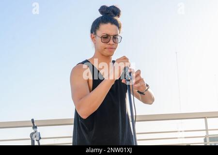 portrait of young latino sound engineer man, with glasses, concentrated, working installing microphone on a tripod. copy space. Stock Photo