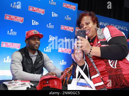 Former Atlanta Falcons and Philadelphia Eagles quarterback Michael Vick  wears one of his special edition New Era hats on sale in the NFL Shop at  the Super Bowl Experience on Thursday, Jan.