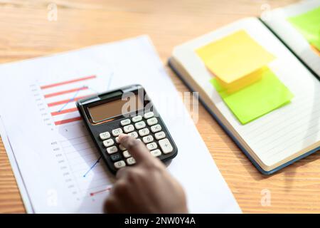 female hands working on monthly budget, using calculator, cropped Stock Photo