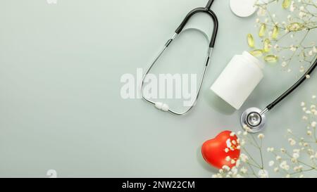 Mockup of vitamins and supplements for healthy heart. White bottle with gel capsules, stethoscope and heart shape hand exercise ball on blue backgroun Stock Photo