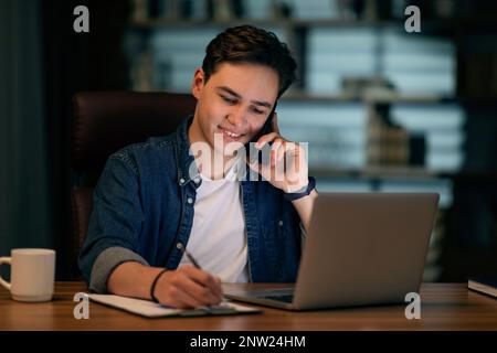 Happy young businessman working late at night Stock Photo