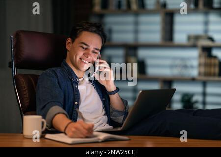 Young guy freelancer working from home office at night Stock Photo