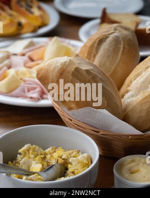 Brazilian breakfast concept with Minas cheese (queijo minas), ham and Prato cheese (queijo Prato) served with corn bread, french bread, under natural Stock Photo