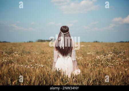 Lone maiden in a summer wheat field Stock Photo
